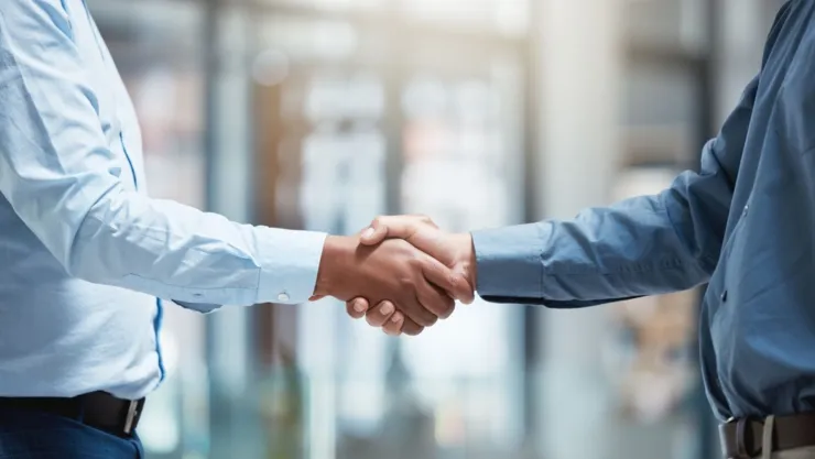 Dos personas se saludan con la mano.