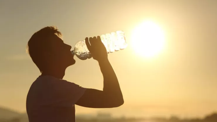 Una persona tomando agua en medio de una ola de calor.