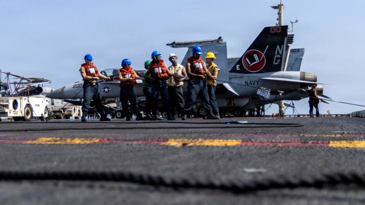 Marineros de la Armada de EE. UU. tiran de una cuerda durante una operación de reabastecimiento de combustible en alta mar en la cubierta de vuelo del portaaviones de clase Nimitz USS Abraham Lincoln durante el ataque de la Operación Furia Épica contra Irán desde una ubicación no revelada el 10 de marzo de 2026.