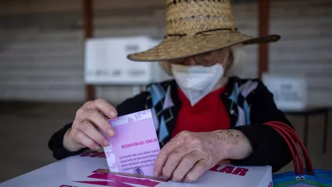 mujer emitiendo su voto en las urnas electorales