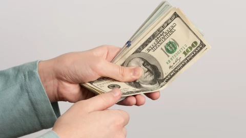 Hombre cuenta billetes de 100 dólares