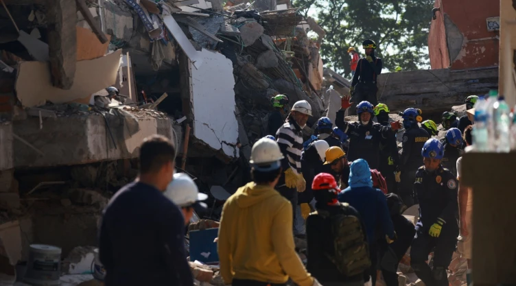 Rescatistas buscan personas entre los escombros tras temblor en Cali, Colombia.