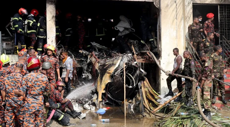 Bomberos y soldados trabajan junto a los restos de un avión de entrenamiento de la fuerza aérea después de que se estrellara en el campus de Milestone College, en Dhaka, Bangladesh , el 21 de julio de 2025
