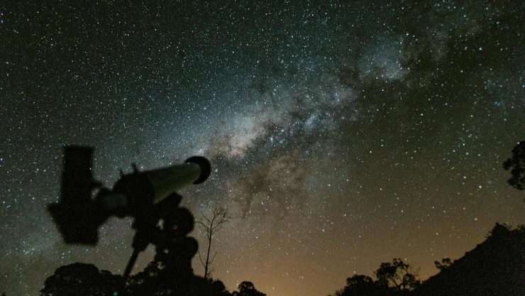 Telescopio apuntando a un cielo nocturno estrellado