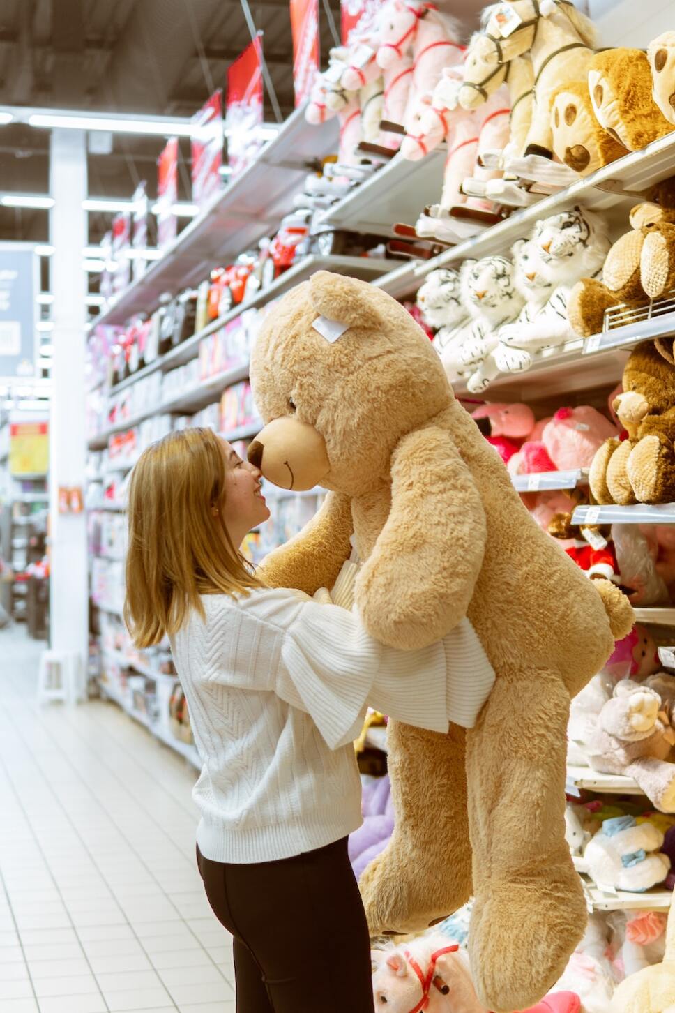 mujer con oso de peluche grande en tienda