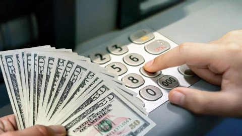 Persona deposita dólares en ATM