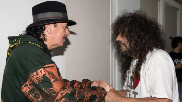 El guitarrista Carlos Santana dando un saludo y apretón de manos con Javier Bátiz