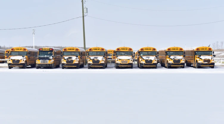 Autobuses escolares estacionados entre la nieve