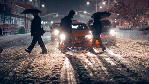 Personas caminan debajo de la lluvia