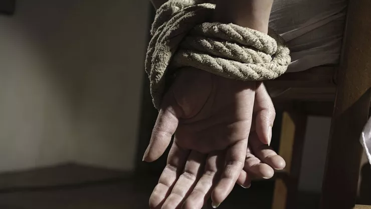 Una mujer estaba atada de manos y pies con los ojos cubiertos con cinta.