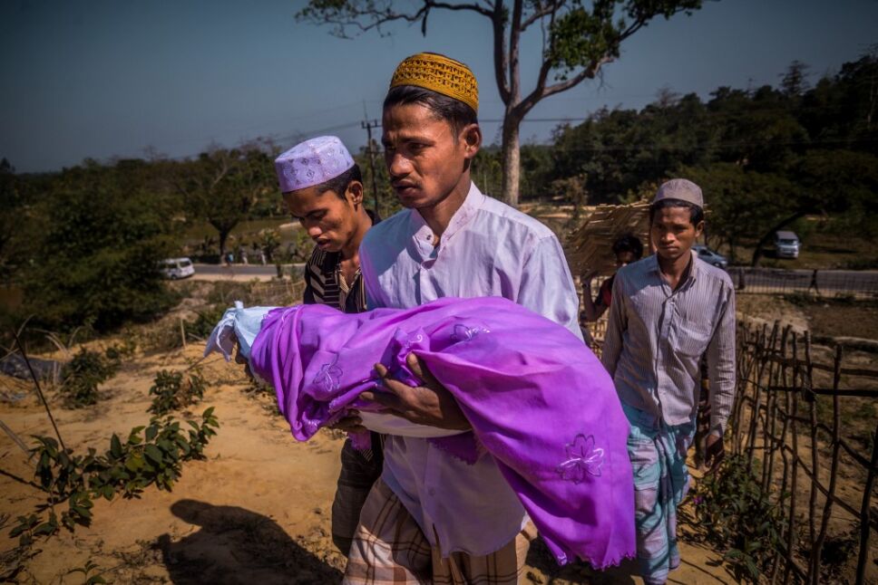padre rohingya cargando el cuerpo de su hijo