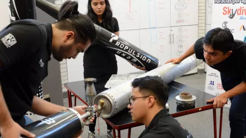 jovenes universitarios ensamblando piezas del cohete
