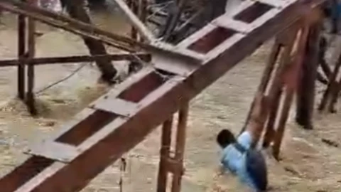hombre cuelga de un puente que es tragado por el agua.png