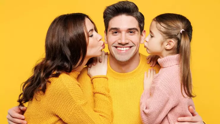 Un padre feliz con su esposa e hija