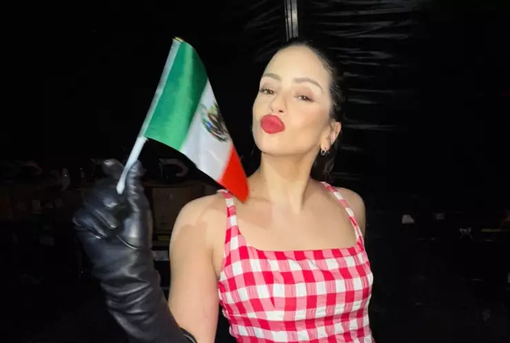 Rosalía sosteniendo una bandera de México