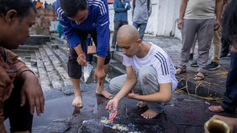 Darshan Bhattarai realiza un ritual funerario durante la cremación de su padre, Pushpa Raj Bhattarai, de 46 años, quien falleció en unas devastadoras inundaciones repentinas y un deslizamiento de tierra. Se utiliza una efigie porque el cuerpo de su padre no ha sido recuperado, en el templo Pashupatinath en Katmandú, Nepal , el 3 de septiembre de 2026.