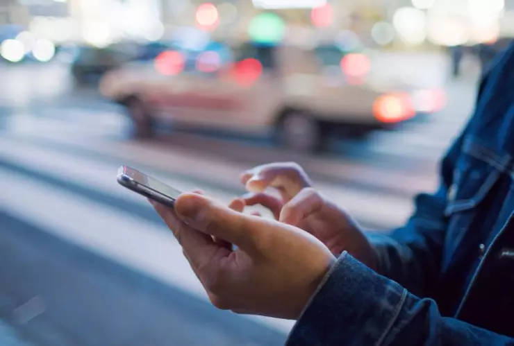 persona sosteniendo un teléfono móvil