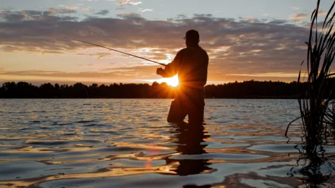 Un hombre está pescando en un lago.