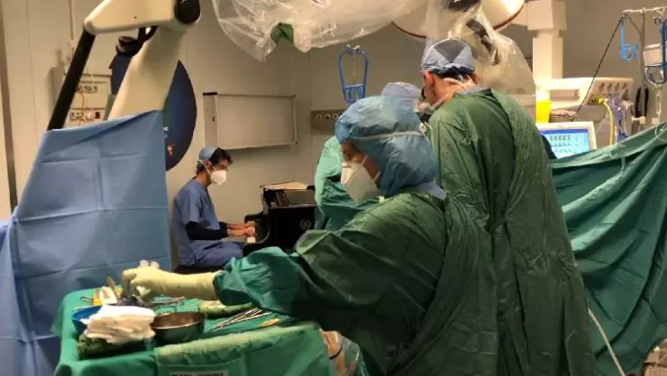 El equipo dirigido por el doctor Roberto Trignani realizaba la cirugía de cuatro horas de duración, mientras el biólogo molecular y músico Emiliano Toso tocaba un piano como efecto terapéutico.