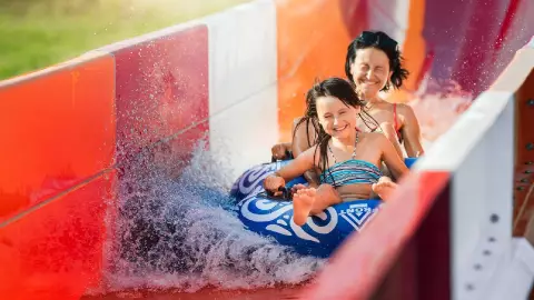 Una familia divirti&eacute;ndose bajo el sol en un parque acu&aacute;tico