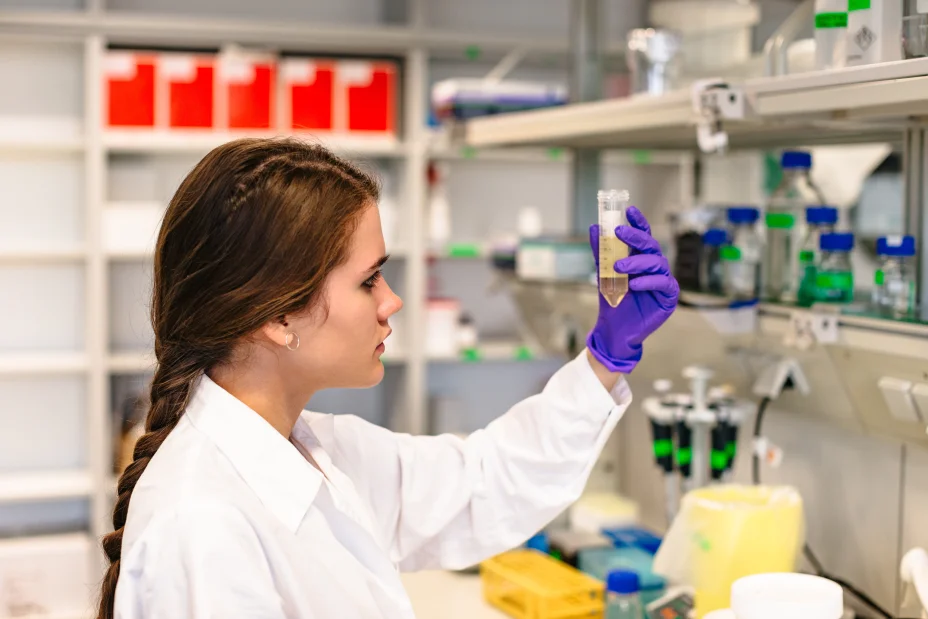 Female scientist holding flask with medicine in laboratory