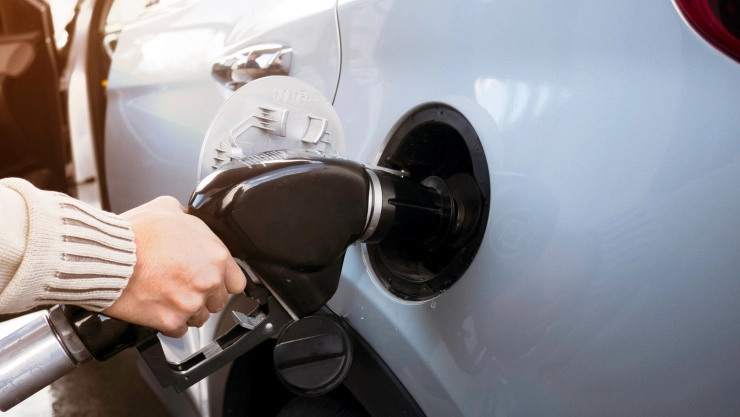 Mujer llena el tanque de gasolina de su coche
