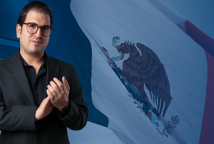 Juan Pablo Delgado con la bandera de México de fondo.