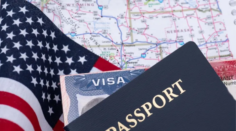 Un visado de Estados Unidos junto a una bandera y un mapa del país.