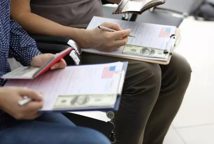Dos personas revisan sus formularios para solicitar visa a Estados Unidos.
