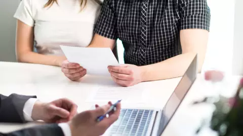 una pareja junto a un abogado para dividir los bienes materiales