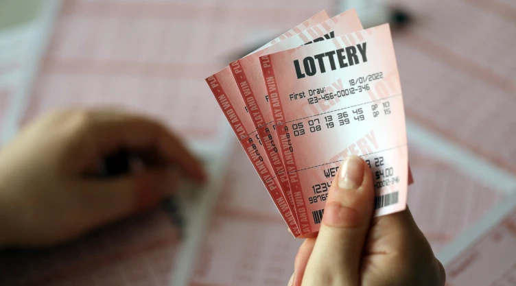 Una mujer sostiene un boleto de lotería