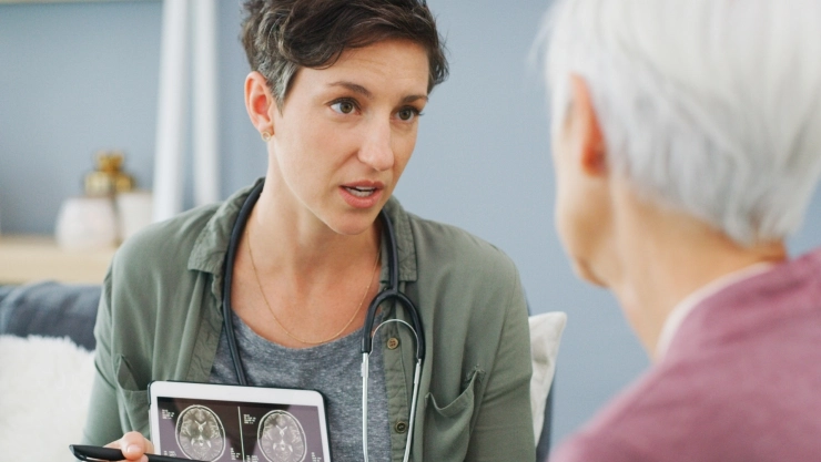 Una profesional de salud muestra un diagnóstico de demencia a un paciente.