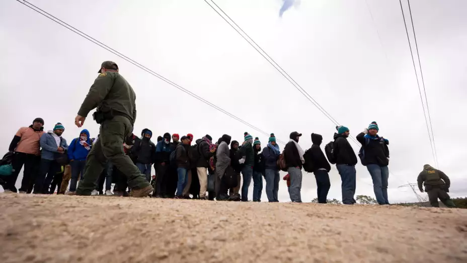 Migrantes peruanos que piden asilo cruzan la frontera de México a EU.