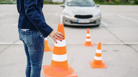 Driving school or test. Beautiful young woman learning how to drive car together with her instructor.
