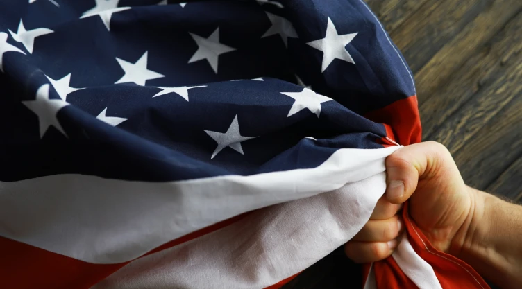 Una persona agarra una bandera de Estados Unidos.