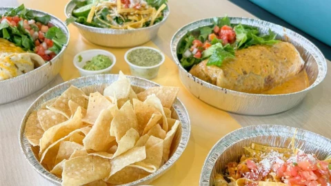 Platos con nachos, tacos y salsas mexicanas
