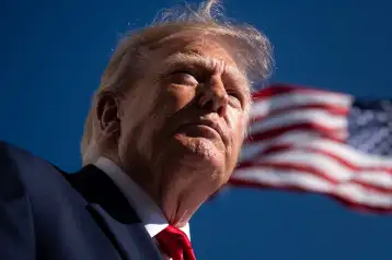 Donald Trump frente a la bandera de EU.
