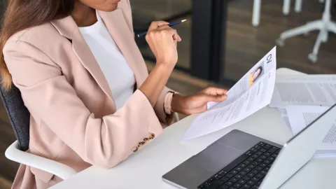 Una mujer revisa la hoja de vida de una persona.