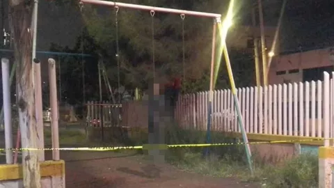 Encuentran a hombre colgado en columpios de un parque de Neza