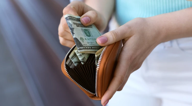 Mujer saca dinero de su billetera
