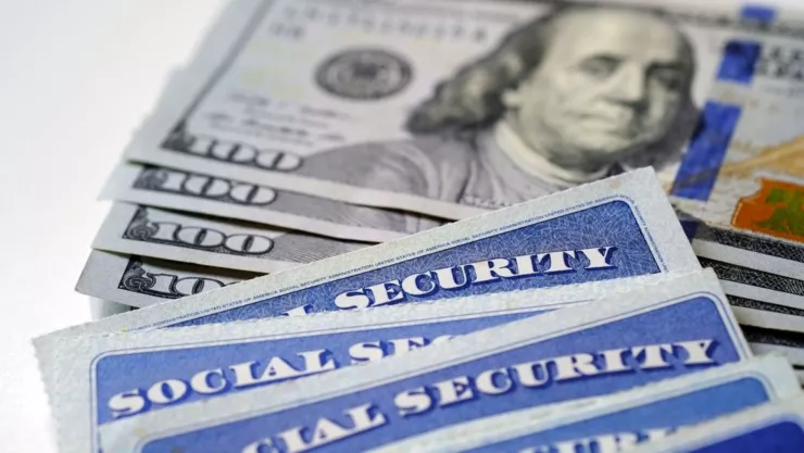 Una tarjeta de la Seguridad Social sobre billetes de 100 dólares.