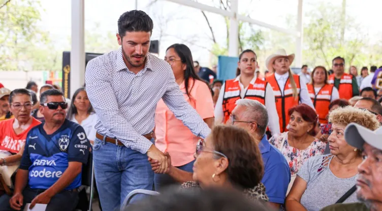 Samuel García, gobernador de Nuevo León, saludando a un hombre de la tercera edad.