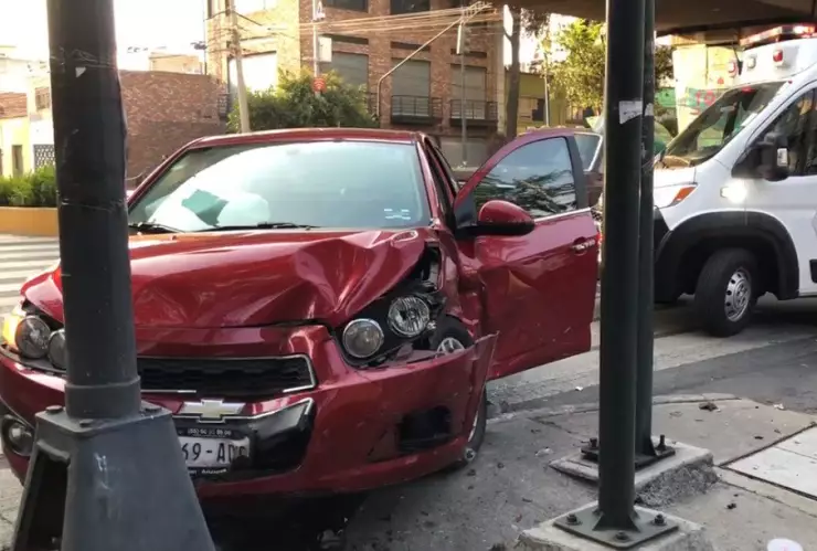 accidente de un carro rojo contra un poste