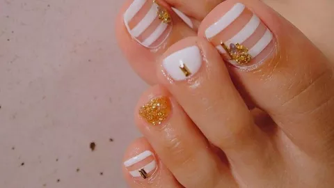 9 diseños de uñas blancas con dorado que puedes usar en los pies para lucir en natación