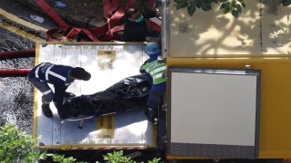 personal de emergencia de hong kong sacando el cuerpo de una de las víctimas del incendio