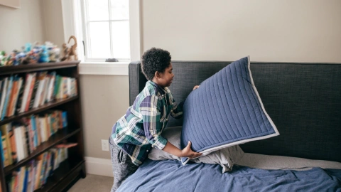 Niños tendiendo la cama