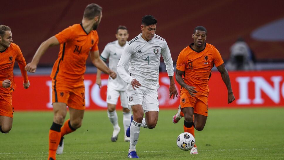 Edson Álvarez de México entre dos jugadores de Holanda