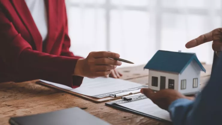 Una mujer le enseña una casa a un hombre.