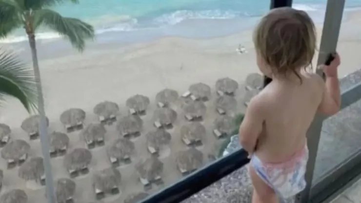 Bebé en la ventana de un balcón