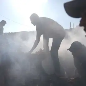 Palestinos reparan un auto dañado tras un bombardeo israelí en Gaza.